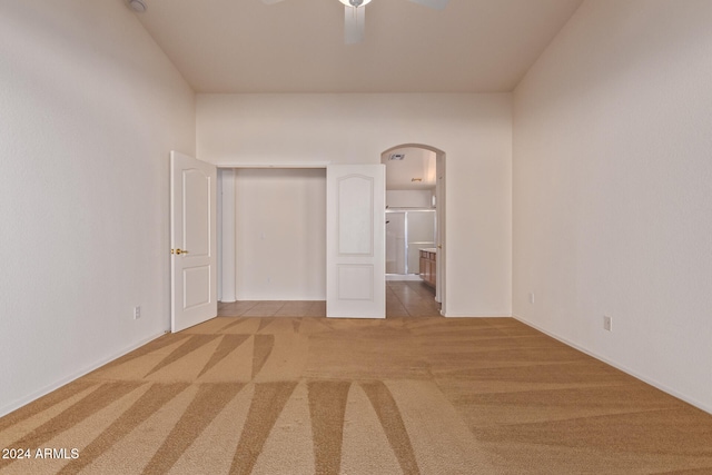 carpeted spare room with ceiling fan