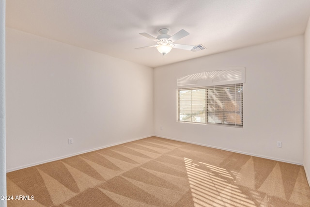 carpeted spare room with ceiling fan