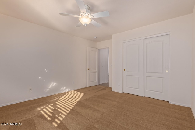 unfurnished bedroom with a closet, carpet floors, and ceiling fan