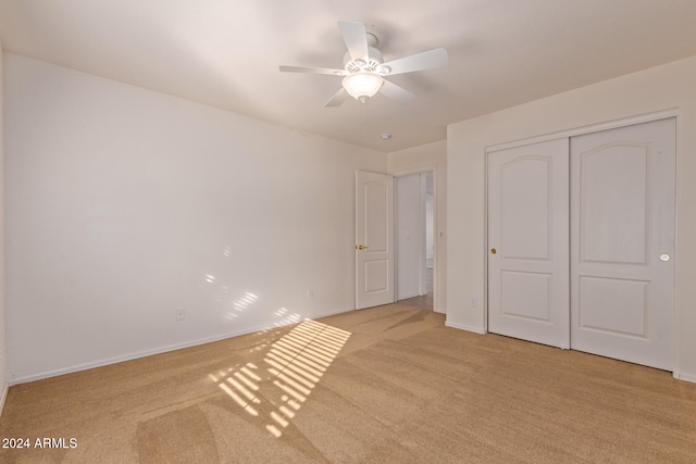 unfurnished bedroom featuring a closet, ceiling fan, and light colored carpet