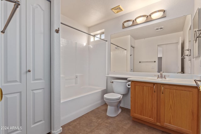 full bathroom featuring tile patterned floors, toilet,  shower combination, vanity, and a textured ceiling