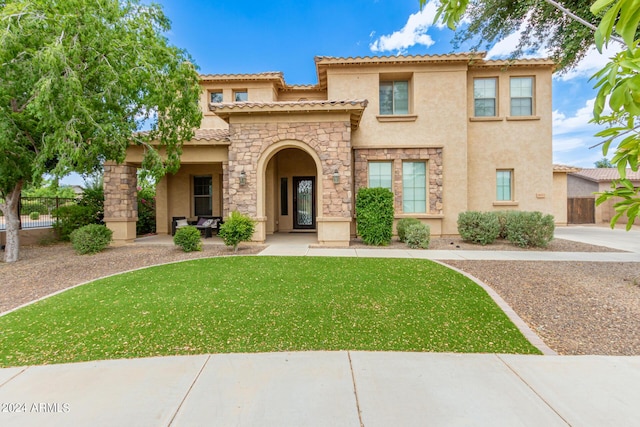 mediterranean / spanish home with a front yard