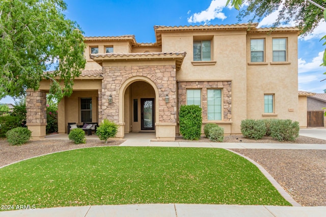 mediterranean / spanish-style home with a front yard