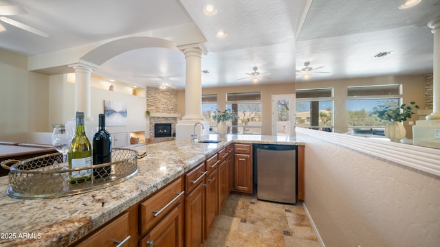 kitchen featuring a sink, decorative columns, open floor plan, and ceiling fan