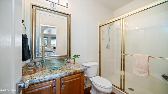 full bathroom with a stall shower, toilet, and vanity