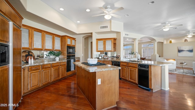 kitchen with a peninsula, a ceiling fan, visible vents, and ornate columns