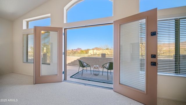 entryway featuring carpet floors and high vaulted ceiling