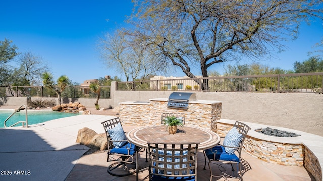 view of patio featuring area for grilling, fence, grilling area, a fire pit, and a fenced in pool