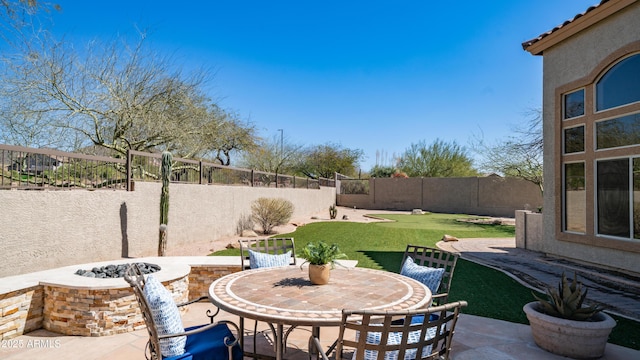 view of patio / terrace featuring outdoor dining area, a fenced backyard, and a fire pit