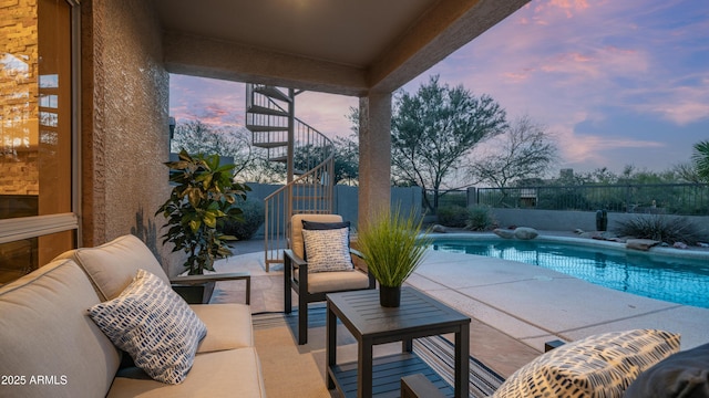 pool at dusk with a patio, a fenced in pool, a fenced backyard, and an outdoor living space