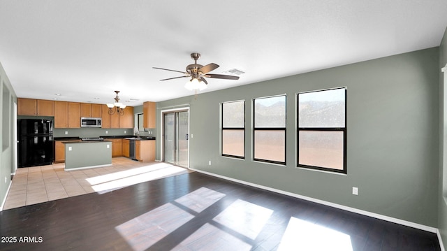 unfurnished living room featuring light wood-type flooring, ceiling fan, and sink