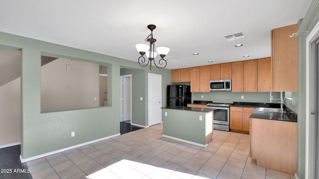 kitchen featuring a center island, an inviting chandelier, hanging light fixtures, appliances with stainless steel finishes, and light tile patterned flooring