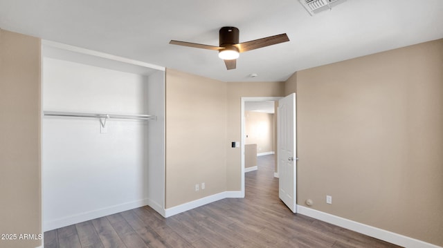 unfurnished bedroom featuring ceiling fan, a closet, and hardwood / wood-style floors