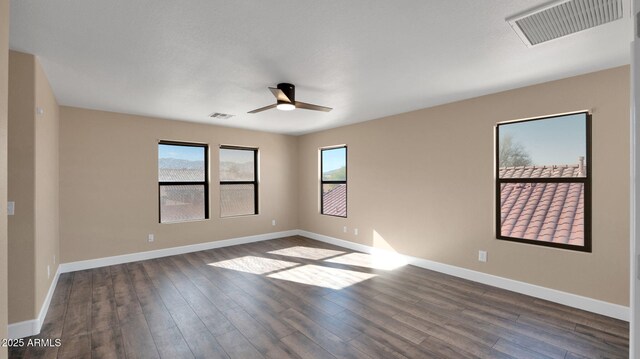 spare room featuring dark hardwood / wood-style flooring and ceiling fan