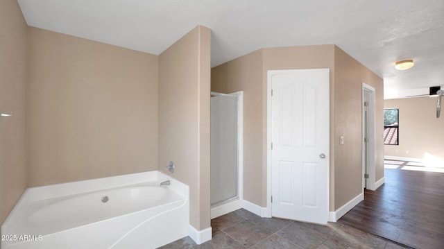 bathroom with ceiling fan and plus walk in shower