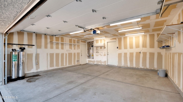 garage with gas water heater and a garage door opener