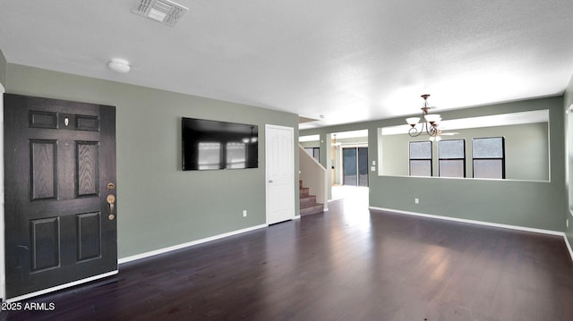 entrance foyer featuring dark hardwood / wood-style flooring and an inviting chandelier