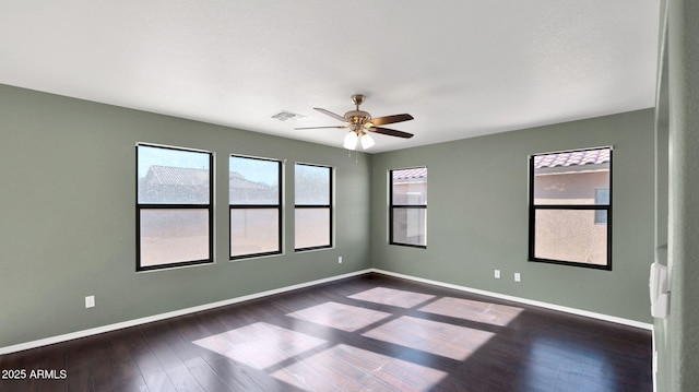 empty room with dark hardwood / wood-style flooring and ceiling fan