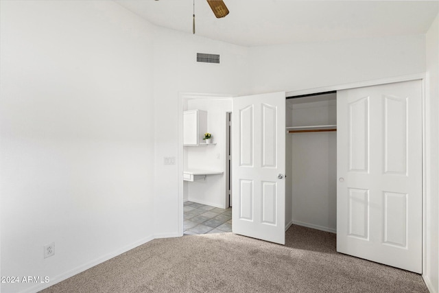 unfurnished bedroom featuring ceiling fan, light carpet, and a closet