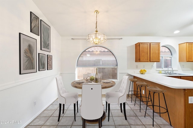 dining area featuring light tile patterned floors, an inviting chandelier, and sink