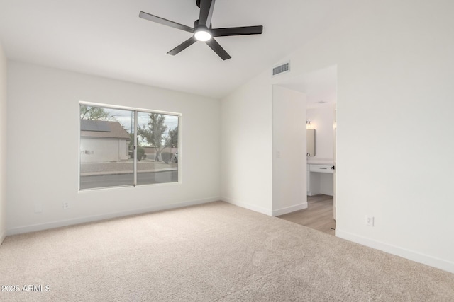 unfurnished bedroom featuring baseboards, visible vents, carpet floors, vaulted ceiling, and connected bathroom