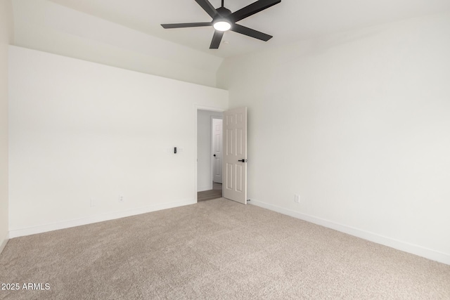 empty room with baseboards, carpet, ceiling fan, and vaulted ceiling