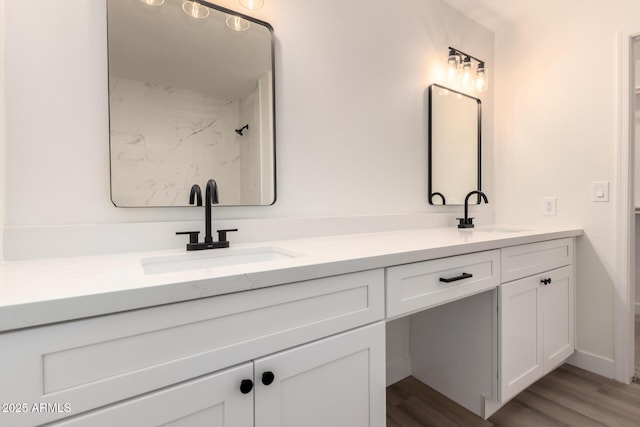 full bathroom with double vanity, walk in shower, wood finished floors, and a sink