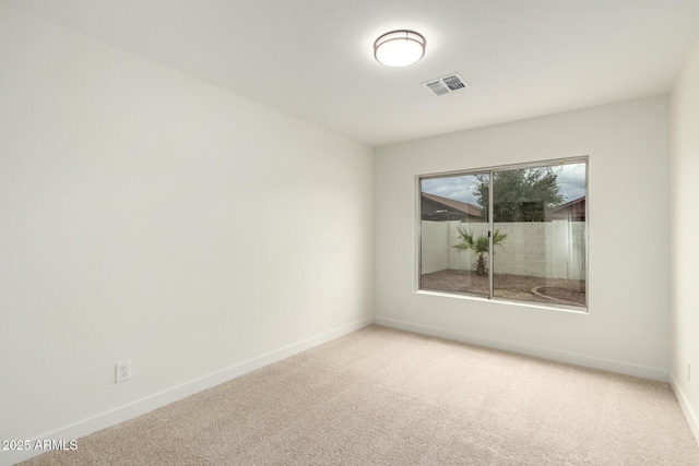 carpeted empty room with visible vents and baseboards