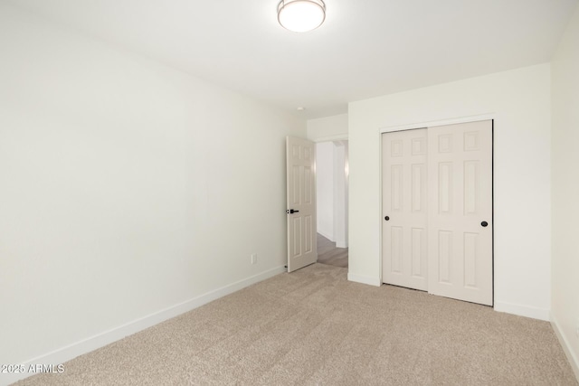 unfurnished bedroom featuring a closet, baseboards, and carpet