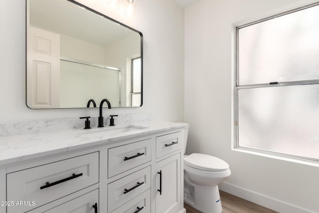 full bathroom featuring an enclosed shower, plenty of natural light, toilet, and vanity