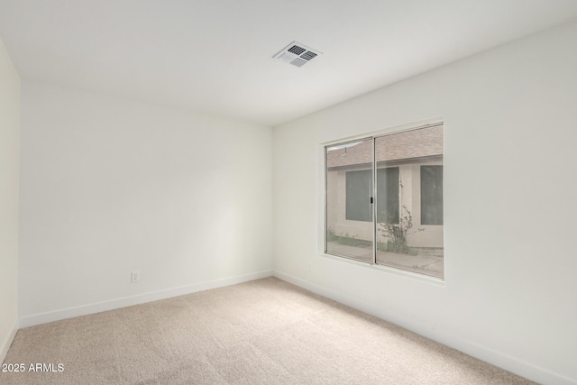 carpeted empty room featuring visible vents and baseboards