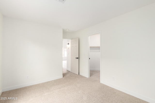 unfurnished room with light colored carpet and baseboards