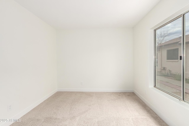 carpeted empty room with baseboards