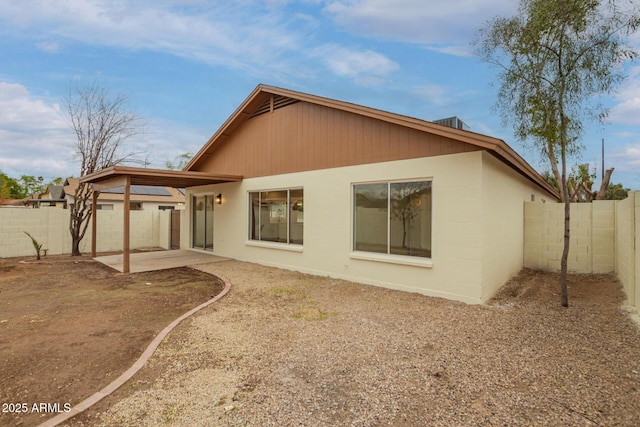 back of property featuring a patio, concrete block siding, and a fenced backyard