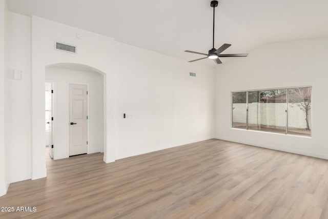 unfurnished room featuring a ceiling fan, visible vents, arched walkways, and light wood finished floors