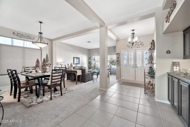 dining area with a chandelier, a wealth of natural light, and light colored carpet