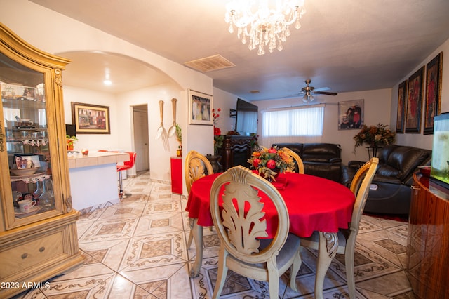 dining space featuring ceiling fan with notable chandelier and light tile patterned floors