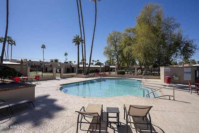 pool featuring fence and a patio