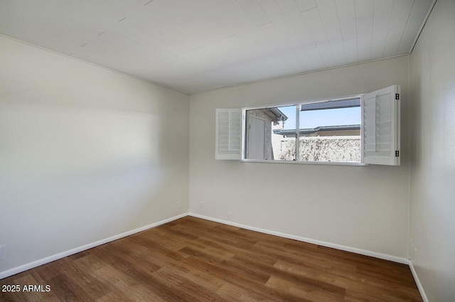 empty room featuring baseboards and wood finished floors