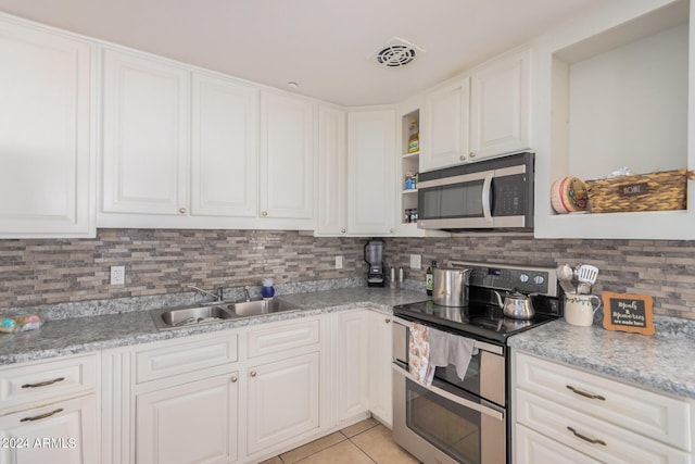 kitchen featuring sink, white cabinetry, stainless steel appliances, and light stone counters