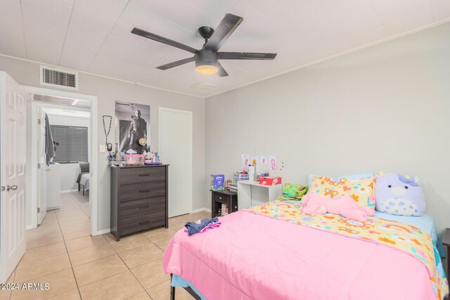 tiled bedroom featuring ceiling fan