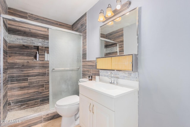 bathroom featuring vanity, toilet, and a shower with shower door