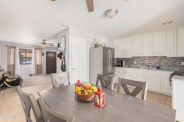 tiled dining space with ceiling fan and sink