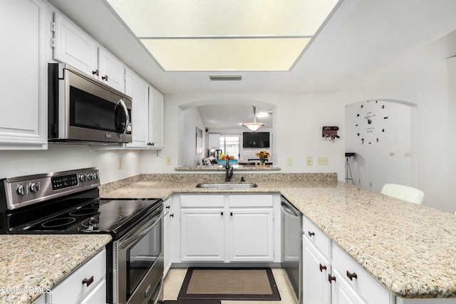 kitchen featuring white cabinetry, appliances with stainless steel finishes, kitchen peninsula, and sink