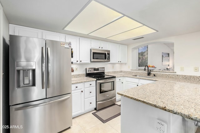 kitchen with sink, appliances with stainless steel finishes, white cabinetry, light stone countertops, and kitchen peninsula