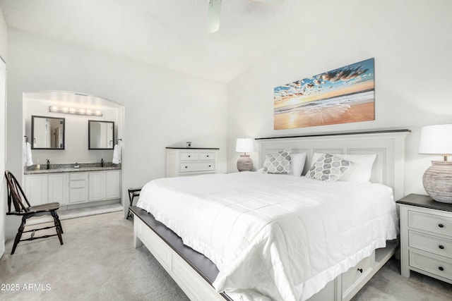 bedroom with light carpet and ensuite bath