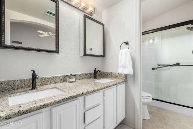 bathroom with vanity, ceiling fan, walk in shower, toilet, and tile patterned floors