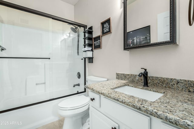 full bathroom featuring vanity, shower / bath combination with glass door, and toilet