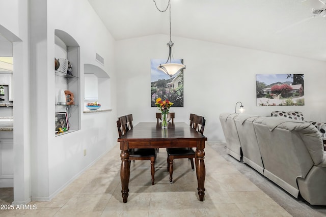 tiled dining space with lofted ceiling and built in features