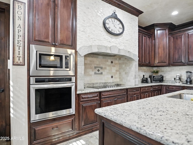 2822 E Constance Way, Phoenix, AZ 85042 - kitchen featuring stainless steel appliances, backsplash, light stone countertops, exhaust hood, and dark brown cabinets